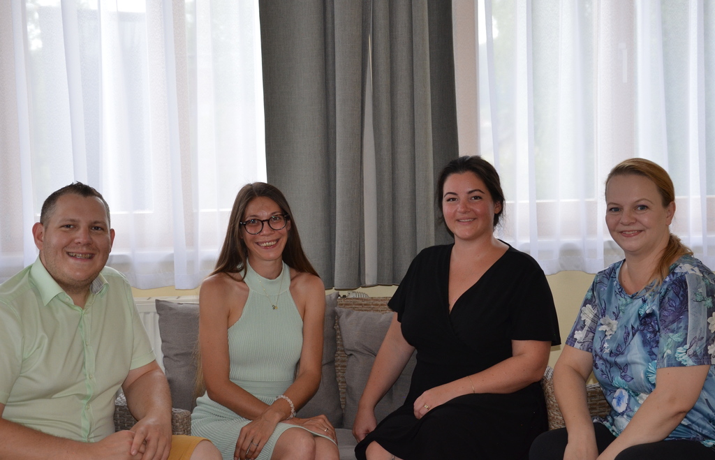 Vier Teammitglieder der Seewald Services GmbH sitzen gemeinsam auf einem Sofa, lächeln in die Kamera und wirken entspannt im Büroambiente.