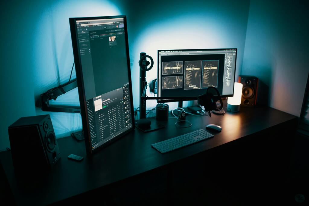 Modern eingerichteter Arbeitsplatz mit zwei Monitoren im Dunkelmodus, Symbolbild für digitale Prozesse KI-Implementierung & KI-Tools bei Seewald Services